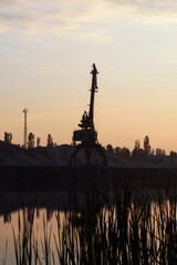 The silhouette of port crane against the sky.