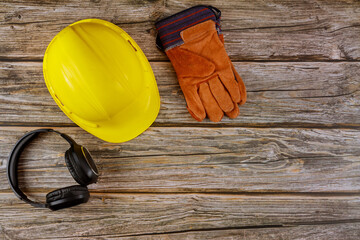 Equipment safety standard construction safety earmuffs leather safety helmet protective gloves on wooden table