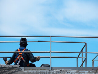 Man Working on the Working at height on construction site with blue sky