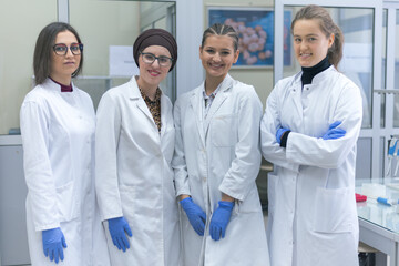 Group of  Laboratory scientists working at lab with test tubes, test or research in clinical laboratory.Science, chemistry, biology, medicine and people concept. Smiling into camera