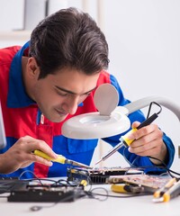 Professional repairman repairing computer in workshop