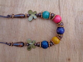 Wooden necklace with brown background. The necklace on the wooden background.