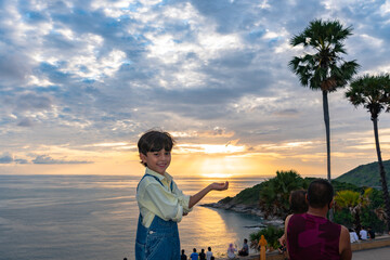 Fototapeta na wymiar .A boy have fun at Promtep cape..Promthep cape is the most popular viewpoint in Phuket island. the most tourist always come to see sunset at this landmark