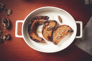 Roasted pumpkin on a withe plate with honey and crushed walnuts. Baked sliced pumpkin.
