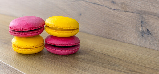 lemon and strawberry macarons stacked on wooden table, panorama

