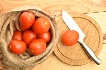 Red plum-like tomato, close-up, on a wooden table.