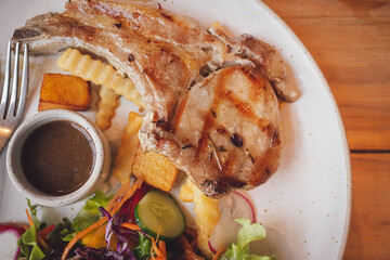 Top view of Grilled steak with french fries and vegetables on plate