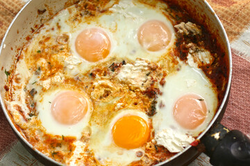 shakshuka - jewish national dish with fried eggs species, tomato, pepper garlic