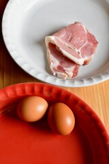 uncooked bacon and eggs 