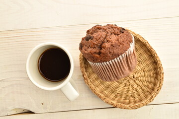 Chocolate muffins on a white wooden table, close-up.