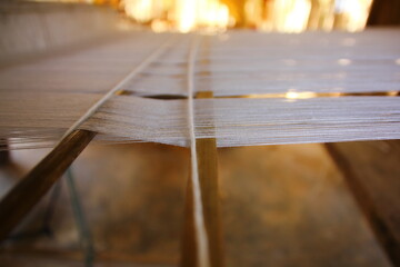 close up white yarns on wood loom weaving ready to produce.