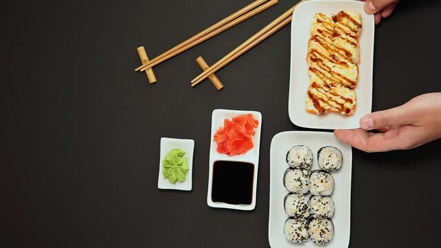 japanese sushi roll, ginger, soy sauce, rustic black background, copy space