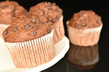 Chocolate muffins, close-up, on a black background.