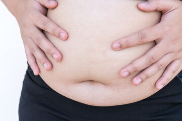 Overweight Fat Asian young woman pinching her belly big in sportswear, overeating problem, obesity. Weight people having more body fat than is optimally, body mass index (BMI), unhealthy concept
