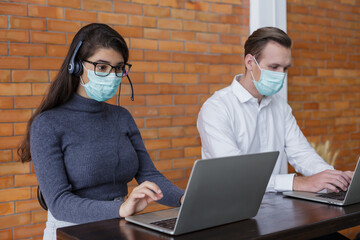 young women and man call center wear headset and mask working with laptop while consulting...