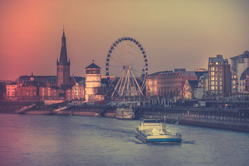 Dusseldorf, Germany - Evening Sunset View of the Boat on Rhine River and the Old Town of Dusseldorf, Germany