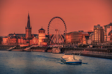 Obraz premium Dusseldorf, Germany - Evening Sunset View of the Boat on Rhine River and the Old Town of Dusseldorf, Germany