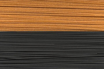 Obraz premium Spaghetti background. Black and brown spaghetti close up. Whole grains