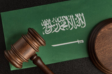 Wooden mallet justice on Saudi Arabia flag. Law library. Law and justice concept.