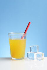 glass of cold orange juice with straw