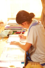 家の机で宿題を一生懸命勉強している子供の横顔