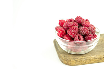fresh ripe raspberry in a glass transparent bowl on white background