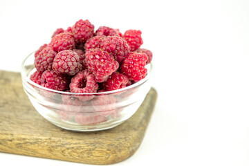 fresh ripe raspberry in a glass transparent bowl on white background