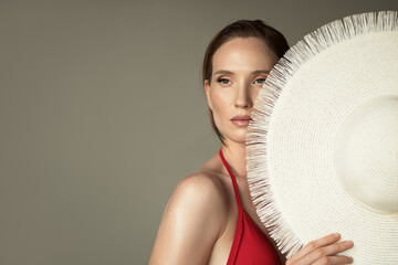 Fashionable portrait of a beautiful girl holding a hat