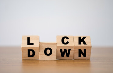 Flipping of wooden cube block which print screen lockdown wording. Due to Corona virus or COVID-19...