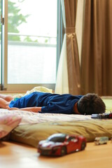 夏バテのため布団でダラダラしている小学生の床の子
