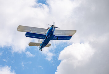 Old and vintage cessna plane flying above the clouds against the blue sky