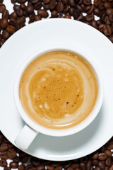 espresso cup on coffee beans, conceptual photography, vertical closeup