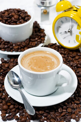 espresso cup on coffee beans on white background, vertical closeup