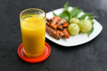 Raw turmeric roots juice, amla, neem leaf Indian Ayurveda natural herbal medicine, Kerala South India. Traditional Indian cuisine use powdered turmeric spices in curry, antiseptic Ayurvedic treatment