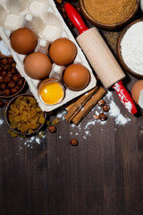 fresh eggs and baking ingredients on wooden table, top view vertical