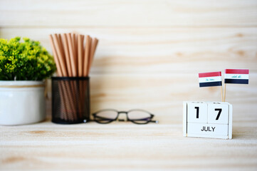 July 17 Wooden calendar and Iraq Flag Concept Iraq national day