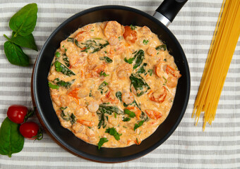 Shrimps with butter sauce placed in a skillet. Pasta with butter sauce shrimps.