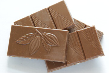 Milk chocolate pieces isolated on white background from top view. Close up a chocolate bar isolated on white background.