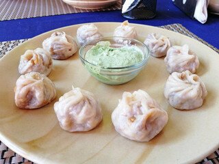 steamed Tibetan momos, the traditional dumplings with different fillings. served with sauce. Close up, side view