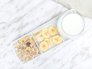 Smoothie ingredients: banana, and cereals next to a glass. Healthy and delicious breakfast, recipe.