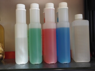 Chemikalien zur ph Einstellung in verschiedenen Farben wie blau, rot, blau und weiß in einem Labor...