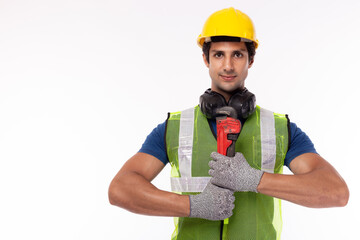 Young manual worker standing, holding adjustable wrench and wear safety hat, isolated white background, copy space. Muscle worker or repairman wearing safety vest, safety glove. ready fix service
