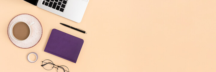 Banner with laptop, mug of coffee, glasses and stationery on a beige background. Distance learning concept with place for text.