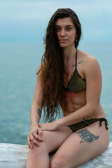 Young woman in bikini by the sea, portrait of a sexy girl on the beach, portrait of a dark-haired...