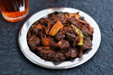 Spicy red beef fry curry and brown rice South Indian dish Kerala, India. side of Ghee rice, Appam, Parotta, Puttu. traditional Christian Muslim feast dish. Buffalo roast, meat pepper fry with coconut.