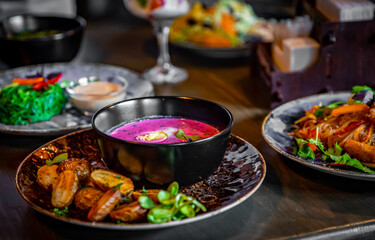 Cold beetroot soup with sour cream, egg and hot potatoes in bowl on table