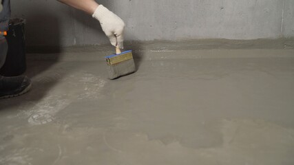 Waterproofing the floor with a brush and mortar. Flooring waterproofing. The master processes the...