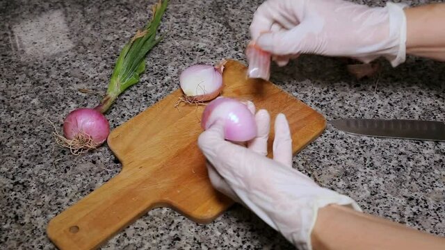 Chef's hands chopping onion and garlic seen from above