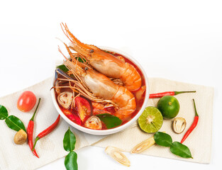 Thai food Tom Yum Kung.Thai hot and spicy soup shrimp in bowl.with Straw Mushroom,lime,Kaffir lime leaves,tomato and chilli. Splash on the air. isolated on white background.