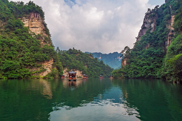Fototapeta na wymiar Tourist boat sailing among karst landscape on Baofeng Lake